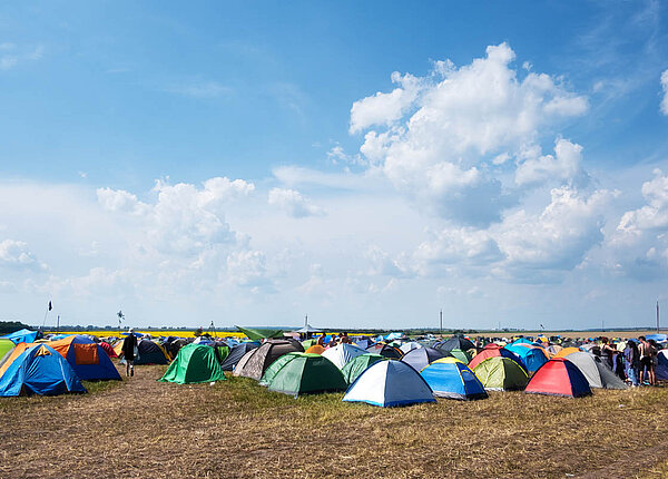 Essen auf dem Festival: Tipps für Snacks und Verpflegung und zum Umgang mit dem Campingkocher auf einem Festival Viele kleine Zelte auf einem Feld