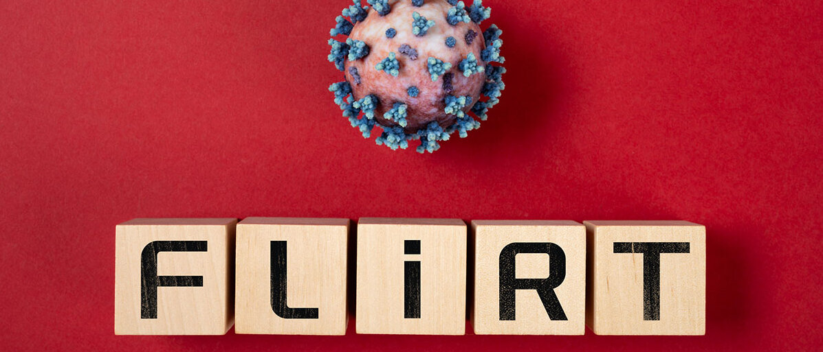 Holzwürfel tragen die Buchstaben F L i R T. Darüber eine Illustration eines Coronavirus mit Spike-Proteinen.