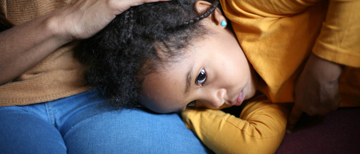 Antibiotika fĂŒrs Kind: Ist danach eine Darmsanierung mit Probiotika nötig, um das Darmmikrobiom zu stabilisieren? Ein kleines MĂ€dchen liegt mit dem Kopf auf dem SchoĂ seiner Mutter, schaut erschöpft und hĂ€lt eine Hand an den Bauch.