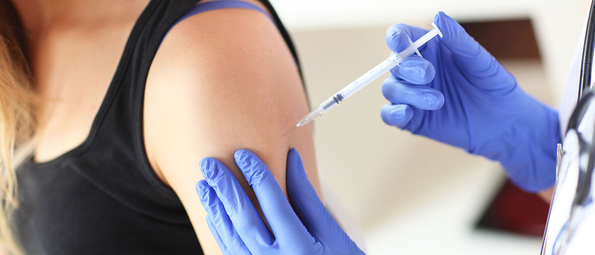 Nahaufnahme des Oberarms einer Frau, die gerade eine Keuchhusten-Impfung erhält.