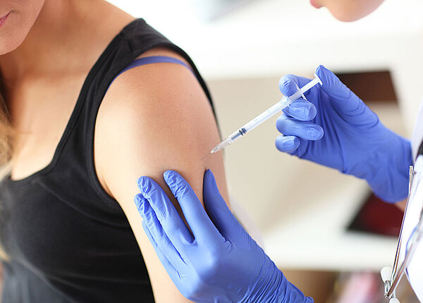 Nahaufnahme des Oberarms einer Frau, die gerade eine Keuchhusten-Impfung erhält.