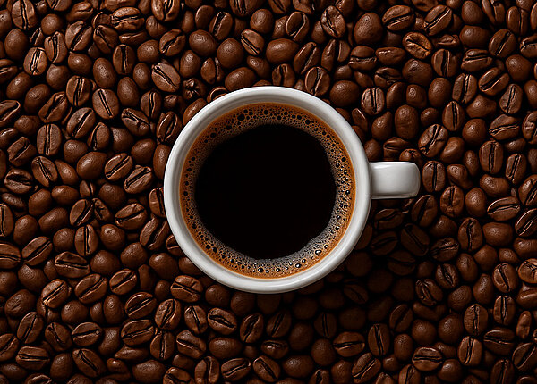 Tag des Koffeins Tasse Espresso inmitten von Kaffeebohnen