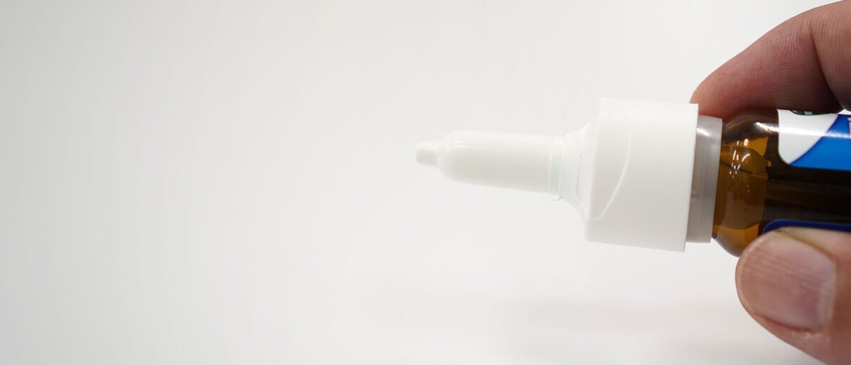 © Nattawat Jindamaneesirikul / iStock / Getty Images Plus NahaufnĂ€hme: Mann hĂ€lt Nasenspray in Hand auf weiĂem Hintergrund