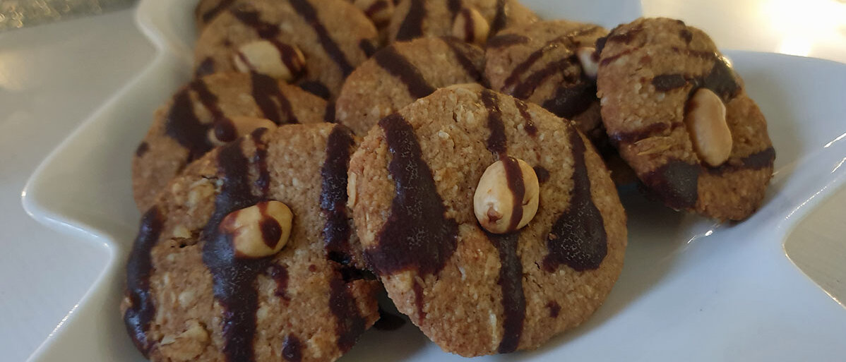 Runde Plätzchen mit Schokolade beträufelt und einer Erdnuss in der Mitte