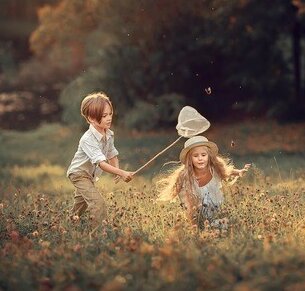 Ein kleiner Junge und ein kleines Mädchen spielen auf einer Wiese