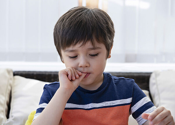 Nägelkauen bei Kindern erkennen und verstehen Kleiner Junge beißt auf seinen Fingernägeln