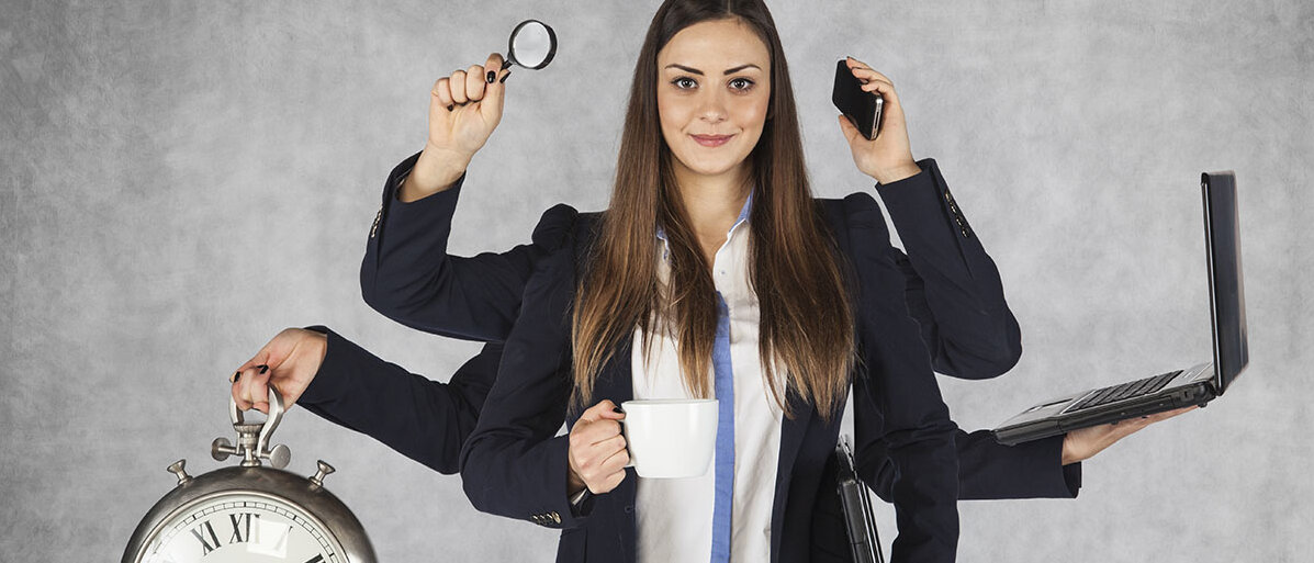 Eine junge, weiße Frau im Business-Kostüm und sechs Armen. In ihren drei linken Händen hält sie jeweils eine Stoppuhr, eine Lupe und eine Kaffeetasse. In ihren rechten Händen hat sie ein Smartphone und einen offenen sowie einen zugeklappten Laptop. 