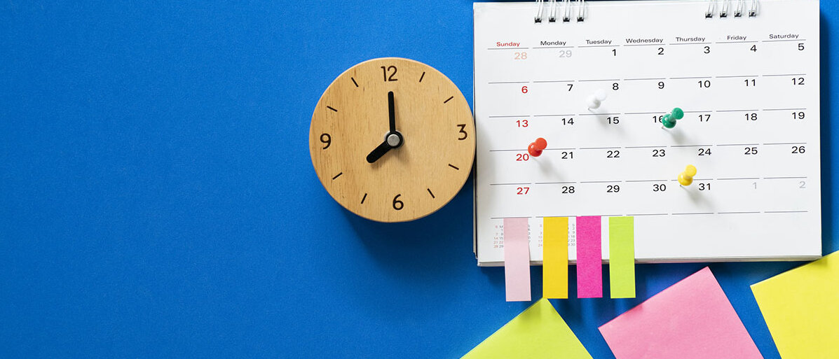 Zeitmanagement-Strategien Nahaufnahme des Kalenders auf blauem Hintergrund mit Pins und Bleistift, der obendrauf liegt