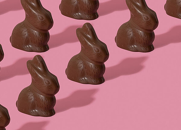 Snacks fürs Osternest Schokoladenosterhasen auf pinkem Hintergrund