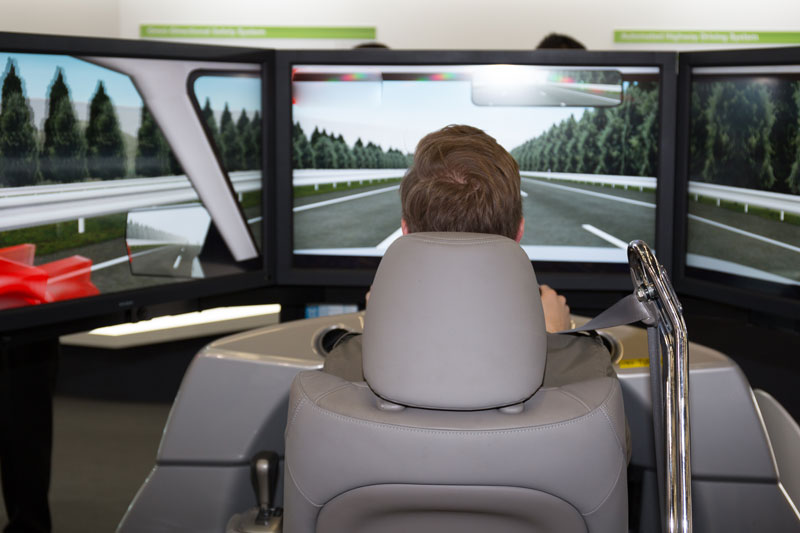 Ein Mann fährt eine Teststrecke im Fahrsimulator.
