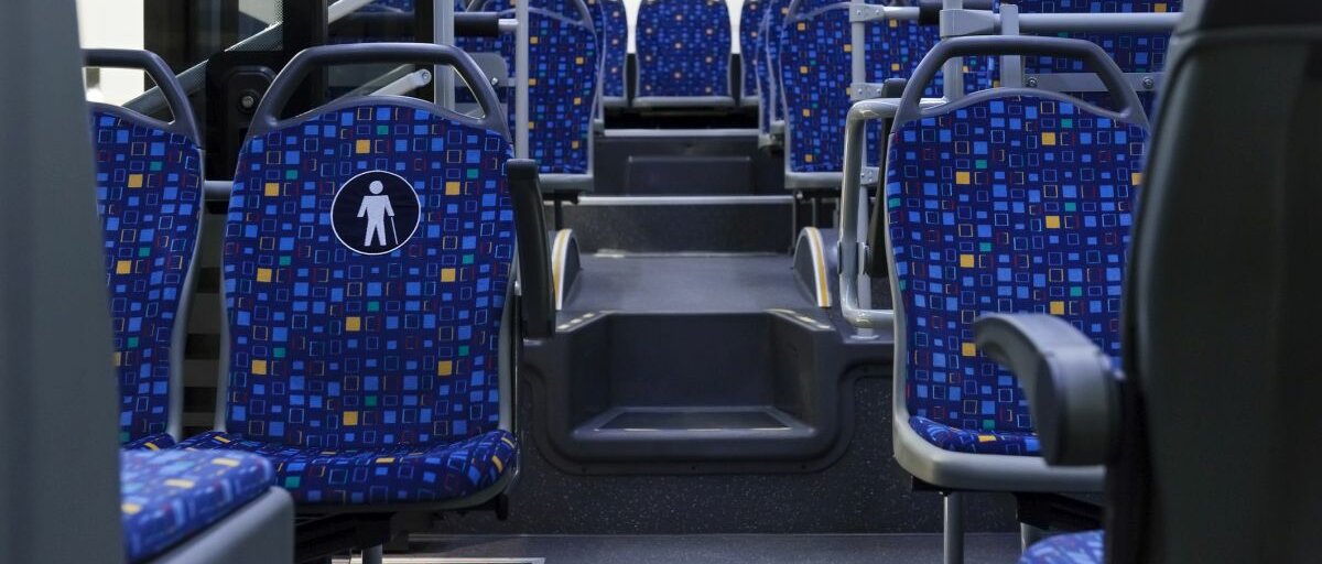 Der hintere Teil eines Busses von innen, dessen Sitze leer sind.