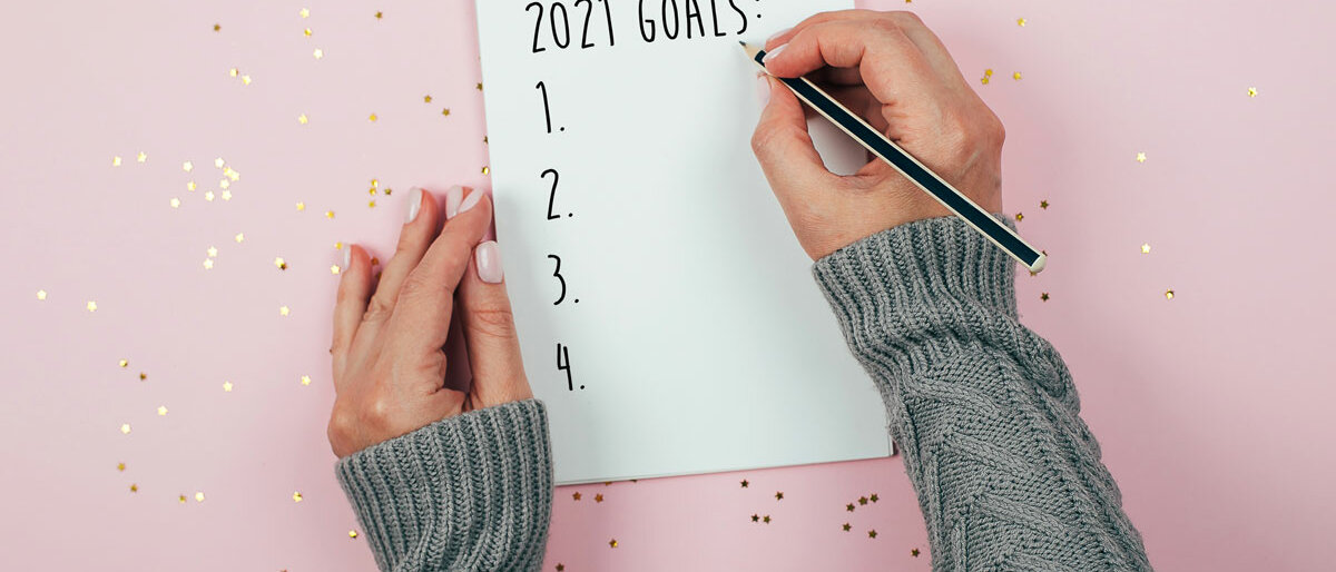 Eine Frau hat einen Block vor sich liegen, darauf steht "2021 Goals". Die Liste ist noch leer.