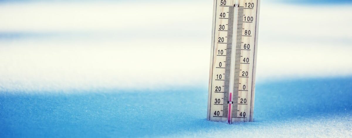 Ein Thermometer, das im Schnee steckt.