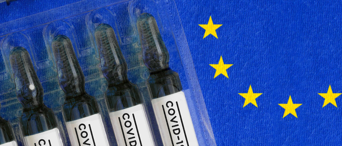Impfstoff-Phiolen mit der Aufschrift "Covid-19" liegen auf einer europäischen Flagge.