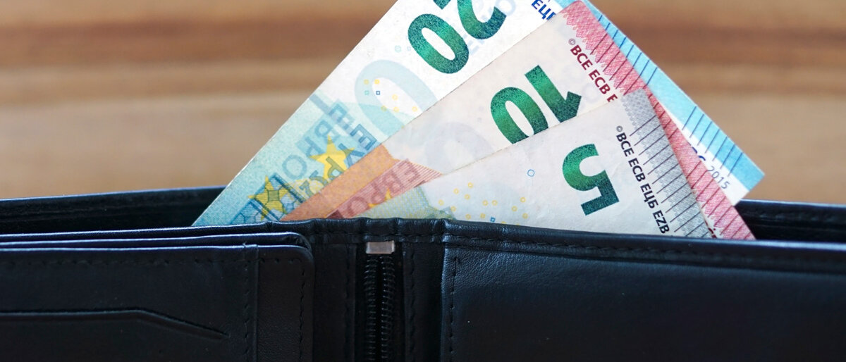 Ein Geldbeutel, aus dem ein 5-, ein 10- und ein 20-Euro-Schein herausschauen