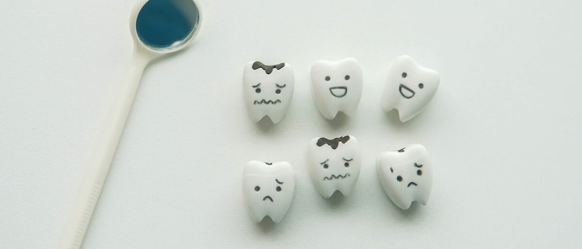 Zahnmodelle mit lachenden und weinenden Gesichtern